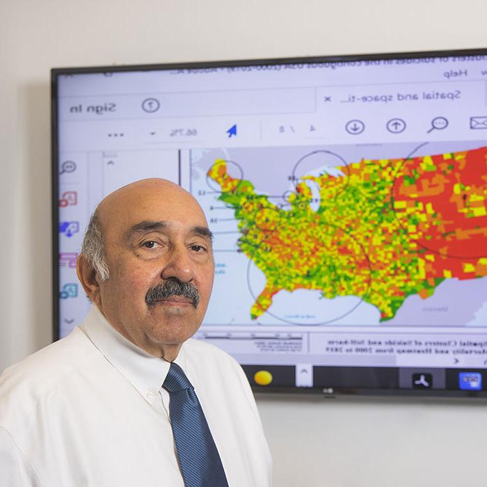 Dr. Raid Amin in front of a map